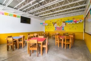 Mesas pequeñas de colores en un aula para preprimaria