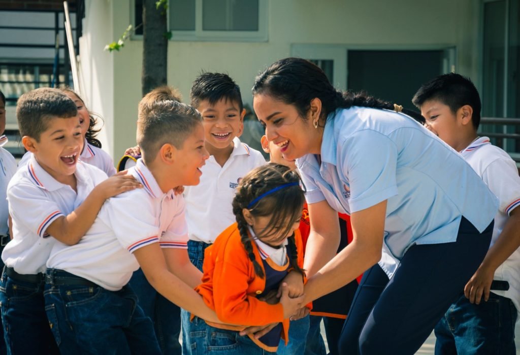 Maestra juega con niños de primaria